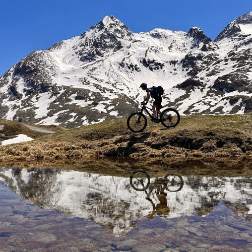 Mountainbiker vor Gletscherpanorama am Bernina Pass auf dem (E-)MTB beitune 3-Länder-Alpencross zum Comer See