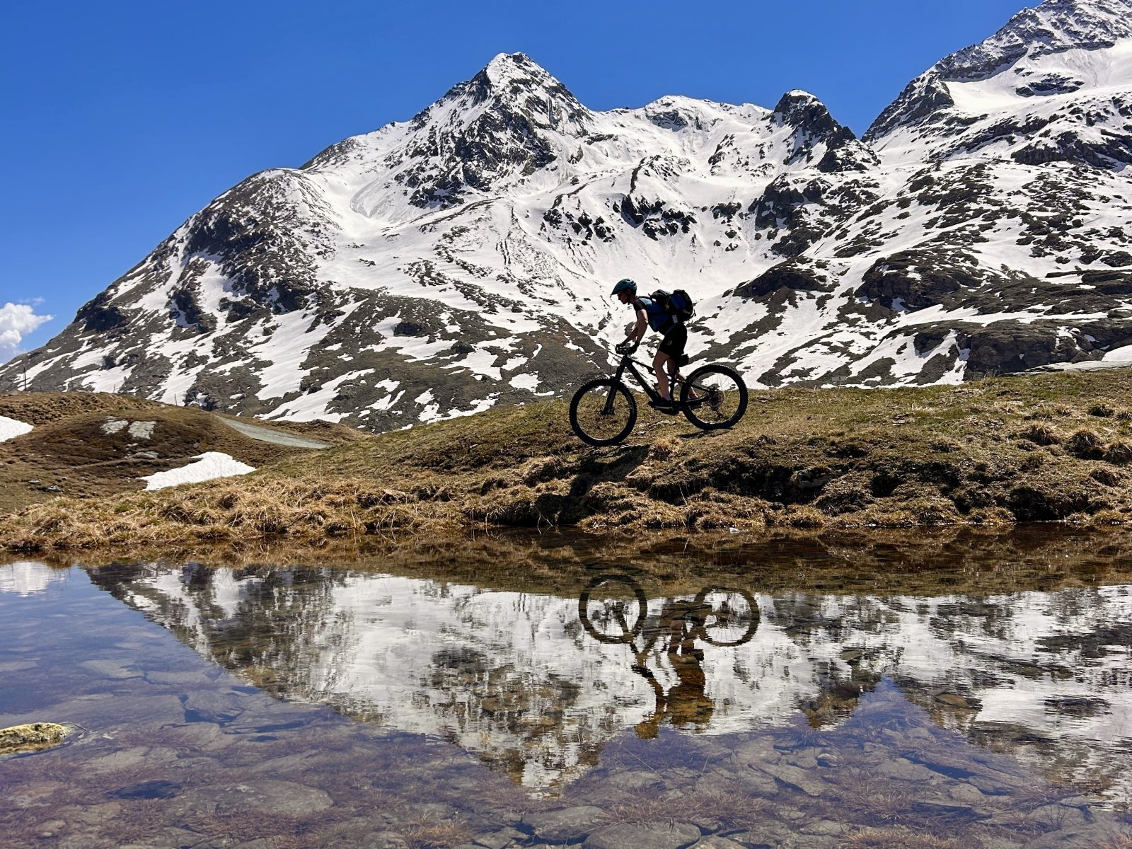 Mountainbiker vor Gletscherpanorama am Bernina Pass auf dem (E-)MTB beitune 3-Länder-Alpencross zum Comer See