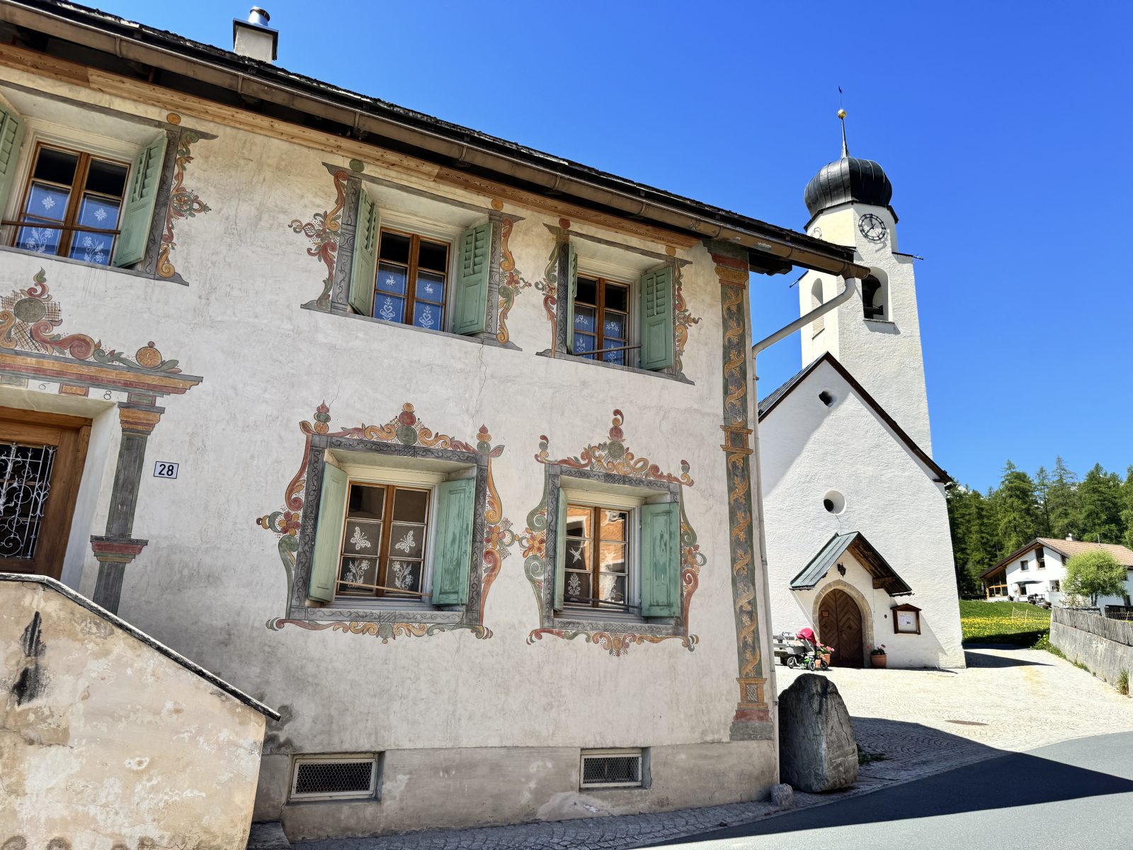 Traditionelle Häuser im Val Müstair sind historische Engadinerhäuser, die Wohnen und Landwirtschaft unter einem Dach vereinen. Sie zeichnen sich durch dicke Steinmauern, tiefe Fensternischen, Sgraffito-Dekorationen und grosse Tore aus.