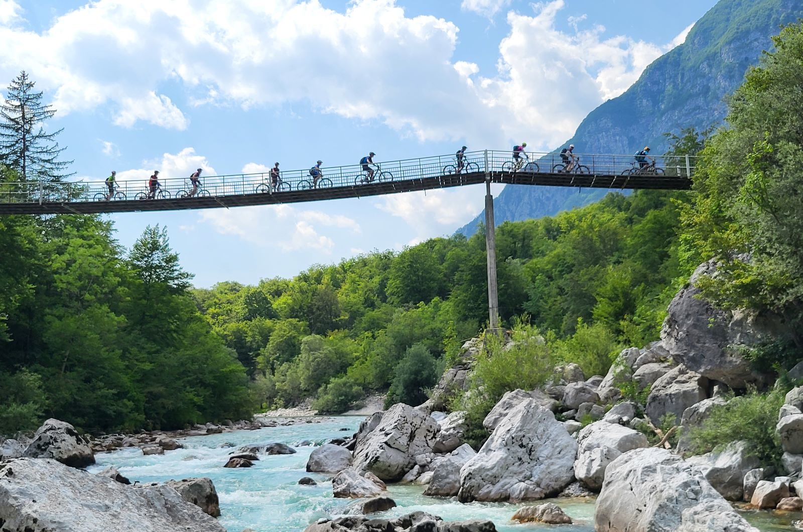 Mountainbiker fahren über eine Hängebrücke im Soca-Tal auf der beitune Trans-Slowenien.